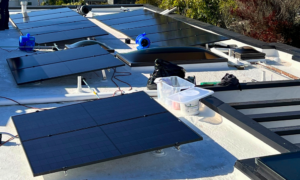 Aerial view of the Sanford family's home in Del Mar, CA, featuring a new flat roof and 16.605 kW solar panel system