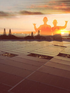 Silhouettes of two installers standing a roof with Suncovia.