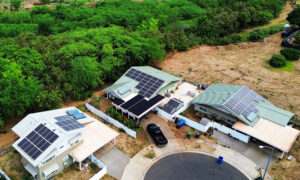 Residential solar installation on three homes in a cul-de-sac surrounded by trees.
