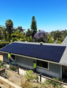 Solar panels on top of a roof with trees shown in the background