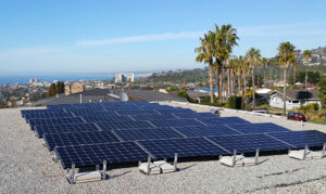 Large solar panel installation on a rooftop with scenic views of the coastline, showcasing Suncovia’s solar energy solutions.