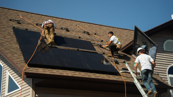 Suncovia installers working on a roof in winter, preparing for the Solar Harvest in New England.