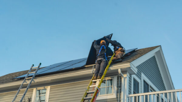 Suncovia solar installers on a snowy roof, setting up panels for the Solar Harvest season.