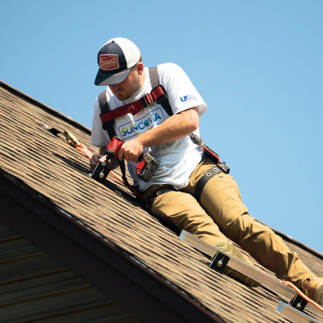 suncovia worker repairing shingles roof