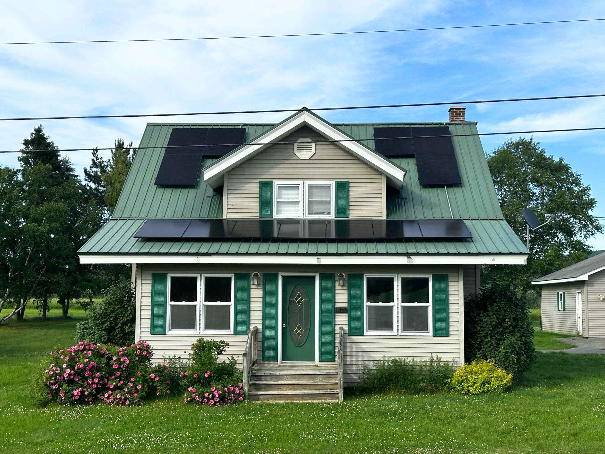 small green house with metallic roof and cute garden