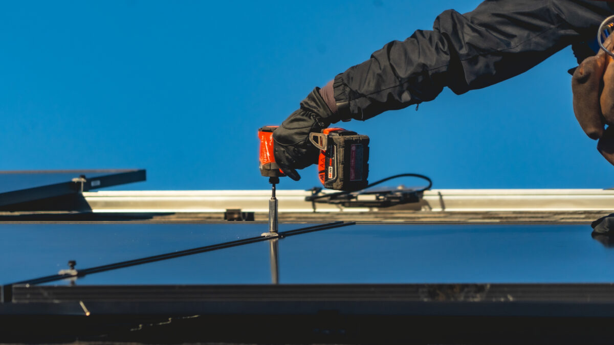 hand holsing screwdriver installing new solar panel