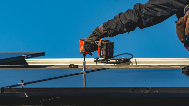 hand holsing screwdriver installing new solar panel