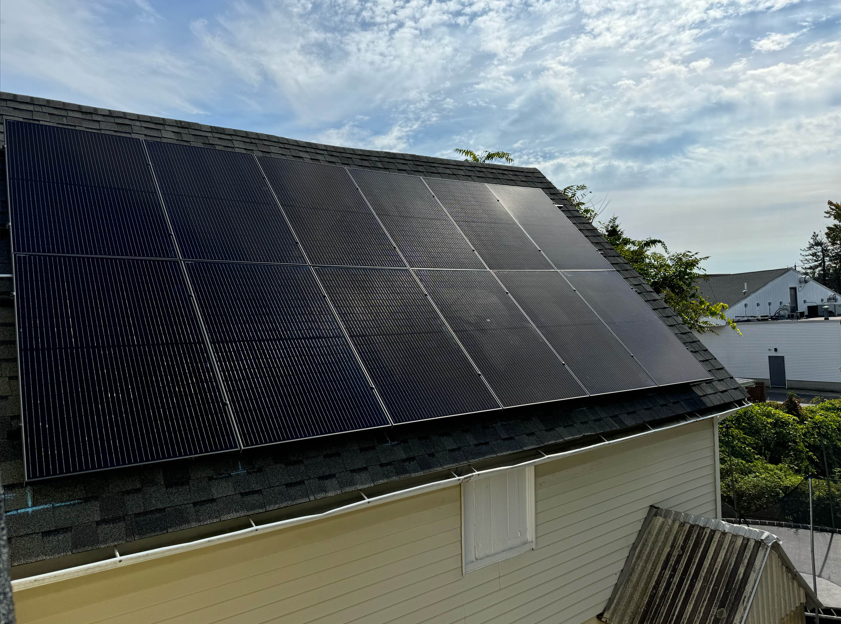 white siding solar panels on top of dark shingles roof